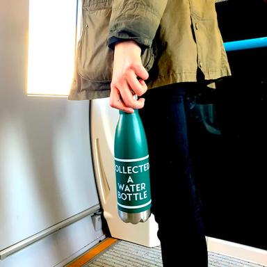A person holding a water bottle with a label reading 'Collected a Water Bottle'